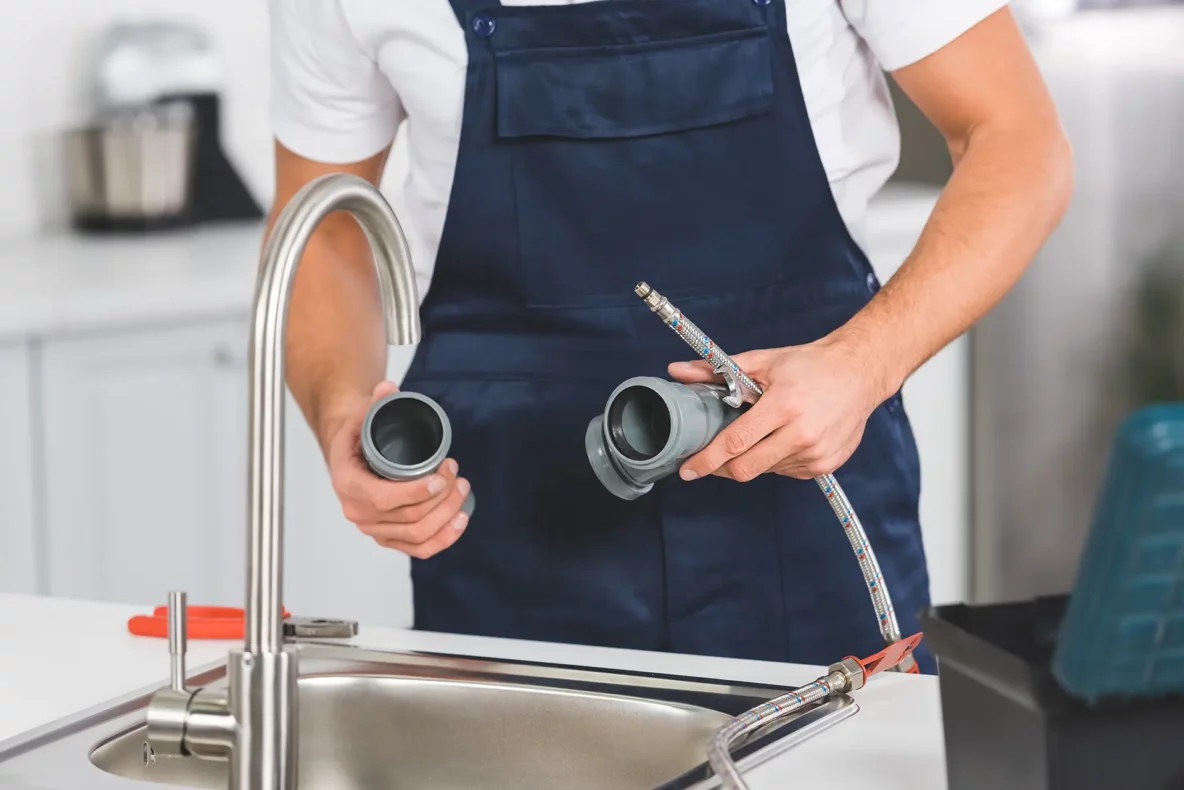 repair man holding pipe pieces