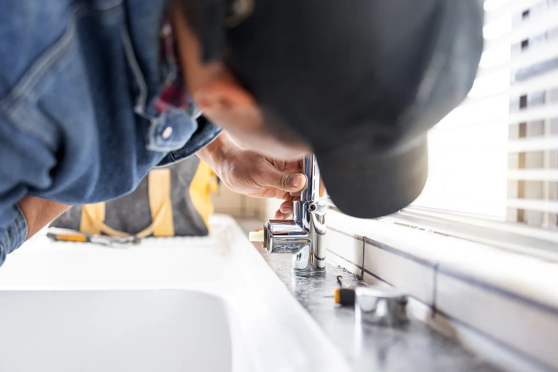 plumber fixing faucet plumbing