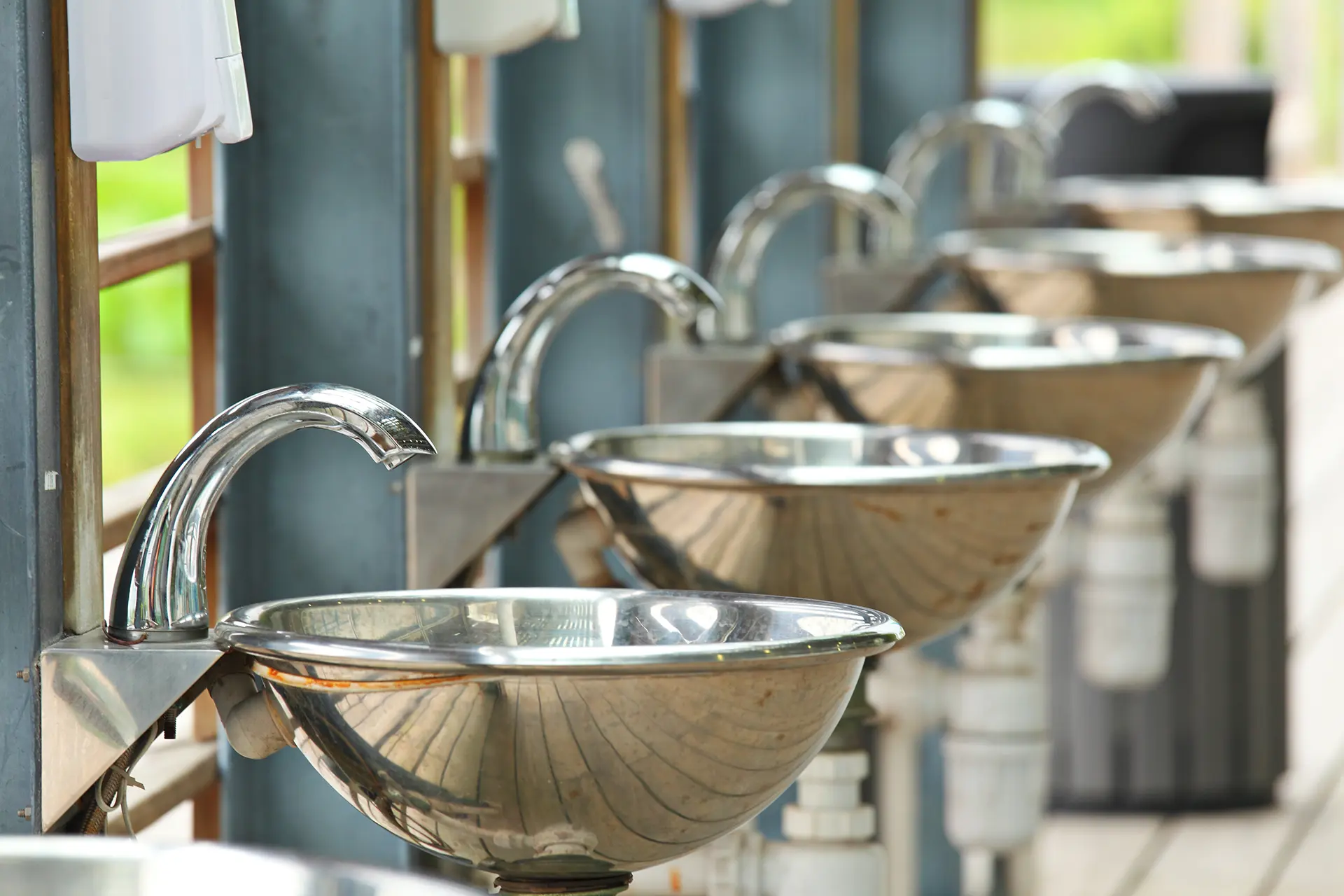 silver sinks-and-taps lined up outdoors